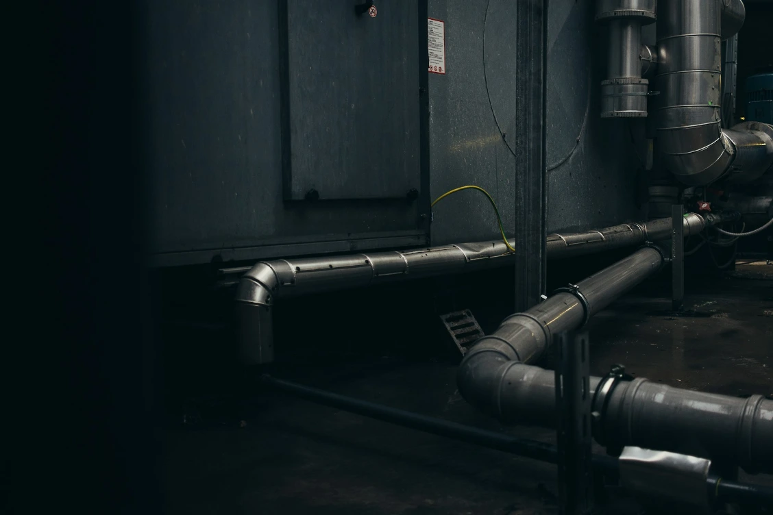 gray pipes mounted on concrete wall arrangement